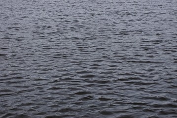 gray texture of water from small dark waves on a reservoir