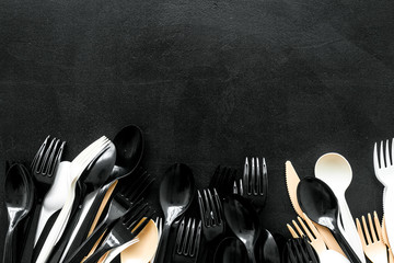 Plastic utilization concept with flatware on black background top view mock up
