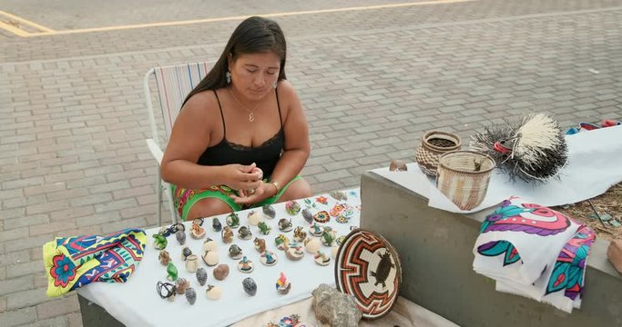 Indigenous woman of Kuna Indians from Dari&eacute;n or Darien province, Panama selling handmade handicrafts, objects in Panama City. Lady of Central American tribe with tourist souvenirs in market shop