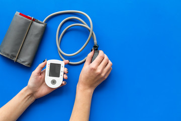 pulsimeter on the desk of the doctor for diagnostics of cardiac disease on blue background top view space for text