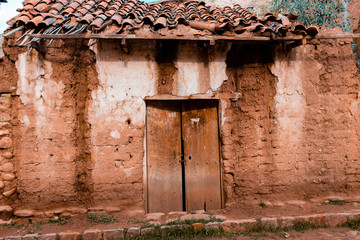 Old house of dirt and colonial tiles, with signs of many leaks and unpainted in Bolivia.