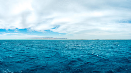 Panoramic photo on the background, blue sea with mountains on the background.
