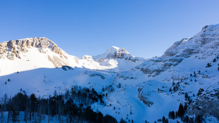 Winter landscape with the mountain peaks covered by heavy snow. Aerial view by drone. 