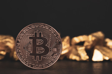 Closeup of bitcoin digital currency and gold nugget or gold ore on black background, precious stone or lump of golden stone, Cryptocurrency money financial and business concept.