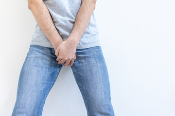 股間を押さえる男性