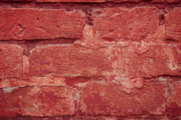 Old grungy brick wall. Free space for an inscription. Can be used as a background or poster. Fragment of a wall with bumps and peeling paint.