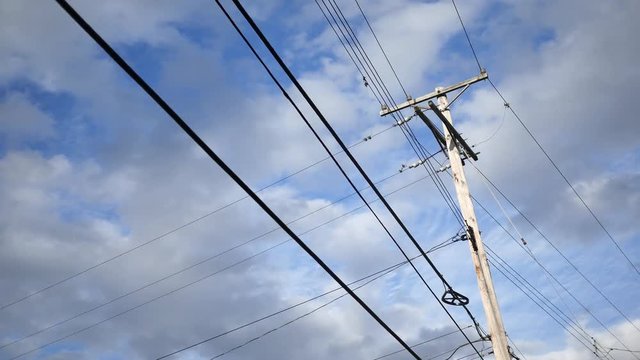 Timelapse of telephone pole electrical lines over sky background