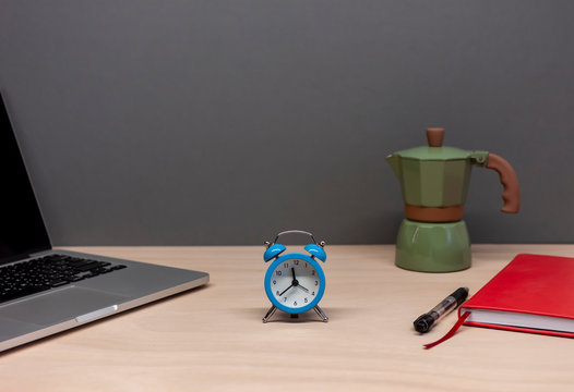working table with laptop notebook alarm clock and italian coffee maker