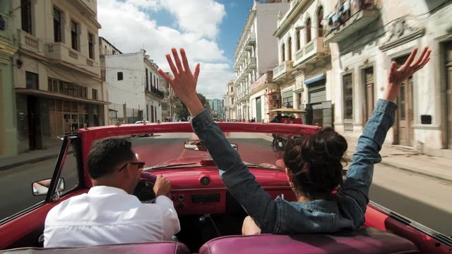 Woman Throwing Arms Into the Air in Vintage Car in Havana Cuba