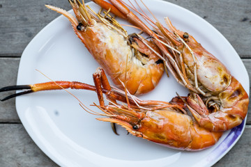 Closeup grilled shrimps on the white plate delicious seafood on the wood table or background