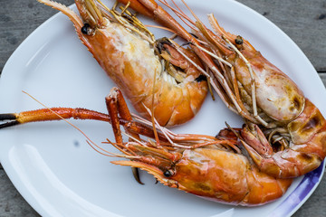 Closeup grilled shrimps on the white plate put on wood background in restaurant Ayutthaya, Thailand seafood 