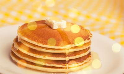 Stack of Small pancakes in syrup on background