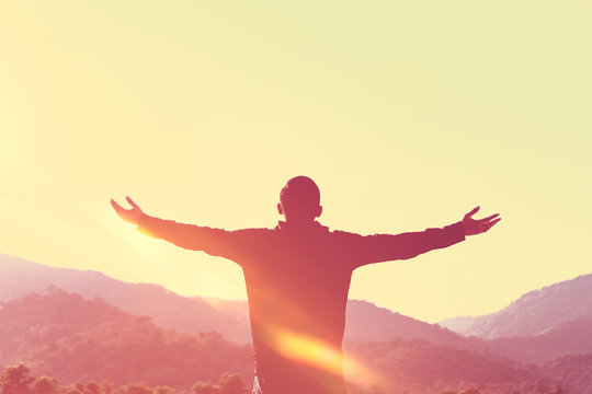 Copy space of man raise hand up on top of mountain and sunset sky abstract background.