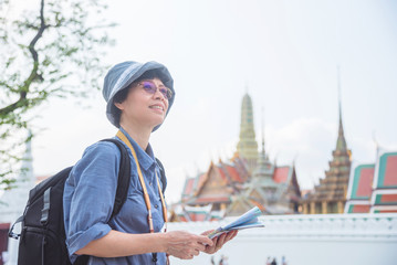 Fototapeta na wymiar Senior asian woman tourist holding a paper map traveling in Bangkok,Thailand.