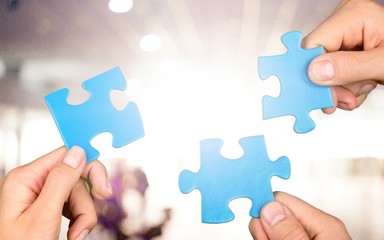 Hands of woman and man holding puzzles