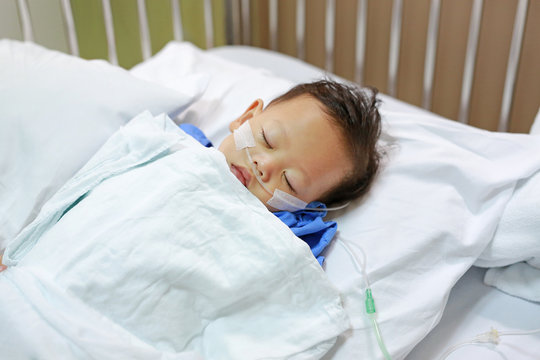 Close up Baby boy on patient bed with tube in nose to deliver oxygen. Respiratory support.