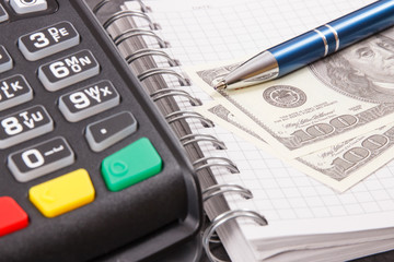 Payment terminal for cashless paying in different places, notepad and currencies dollar
