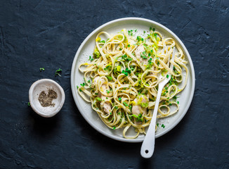 Chicken, leek, linguine pasta carbonara on a dark background, top view