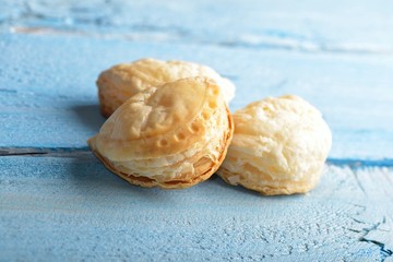 Fototapeta na wymiar Mini cheese filled baked pies isolated on blue wooden background