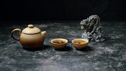 tea ceremony - Chinese dragon, ceramic teapot and cups. Asian culture cuisine concept. Beautiful tea ceremony with dragon statue on blurred dark background. copy space, soft focus