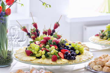 Fruits and beriies in aplte on a buffet table