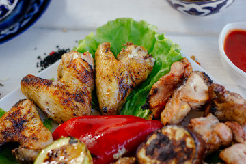 Top view of grilled chicken meat on white plate.