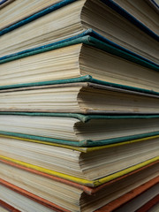 Heap of books of different flowers. The old books put on a table. The turned yellow pages of textbooks