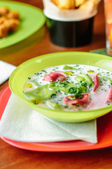 Green and red ravioli in soup for kids.