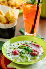 Green and red ravioli in soup for kids.