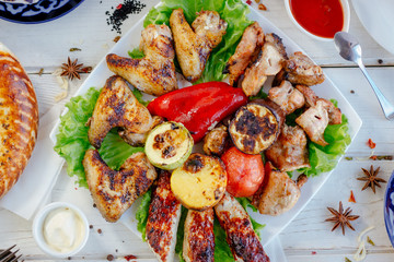 Top view of grilled chicken meat on white plate.