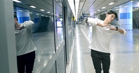Medium shot of young man doing freestyle street dancing in underground station, robot dance. Asian man. - Powered by Adobe