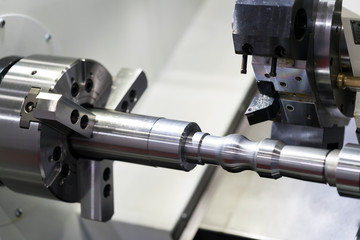 Operator machining automotive part by cnc turning machine,