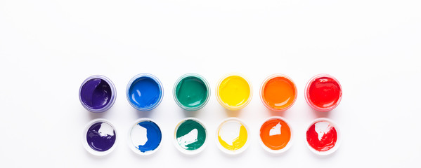 Six jars of paint on a white background Isolated Multicolored gouache Top view Banner Horizontal