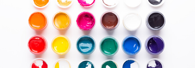 Multicolored gouache on a white background Isolated Paints in containers Top view Banner Horizontal