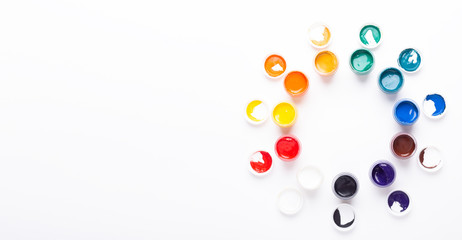 Multicolored gouache on a white background Circle shape Isolated Paints in containers Top view Banner Horizontal