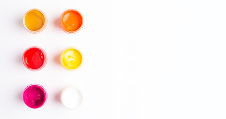 Six jars of paint on a white background Isolated Multicolored gouache Top view