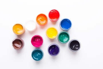 Multicolored gouache on a white background Isolated Paints in containers Top view