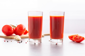 Fresh tomato juice with parsley and spices, selective focus. Glasses with tomato juice and fresh tomatoes on a table 