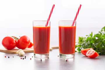 Fresh tomato juice with parsley and spices, selective focus. Glasses with tomato juice and fresh tomatoes on a table 