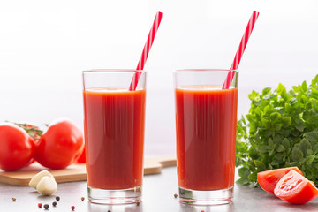Tomato juice with basil and spices. Glasses with tomato juice and fresh tomatoes.
