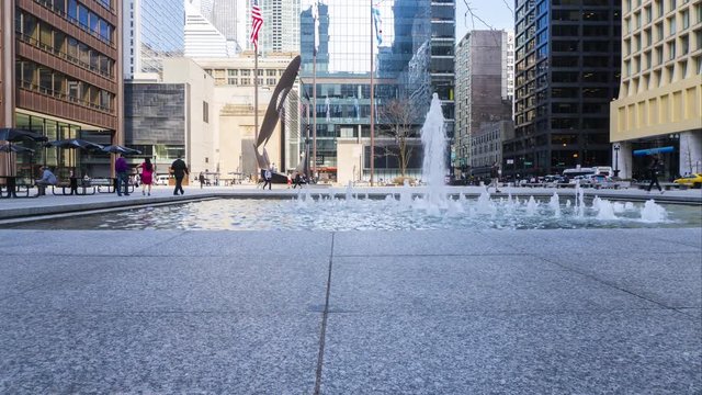 Chicago,Illinois/United States-April 16th, 2019: Time lapse of people having fun on a sunny spring afternoon near the Chicago downtown Daley center water fountain. the sun cast on the architecture 