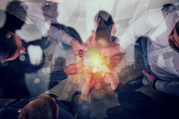 Business people join puzzle pieces. Concept of teamwork and partnership. double exposure.
