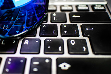 Computer Spanish keyboard close up with blue sunglasses reflection