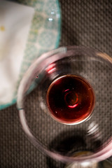 Empty wineglass circle shape with red wine close up on a blurry still
