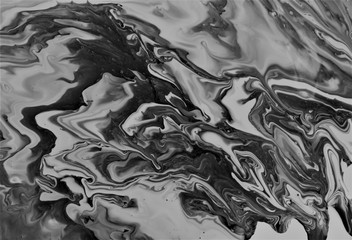 Black paint freely mixed with white. Abstract artistic texture. Acrylic paint and liquid inks are mixed in the water. Color and its transitions create an interesting structure.