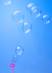 blowing soup bubbles on blue background