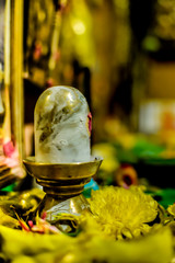 Golden Shiva linga between flowers