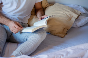 Obraz na płótnie Canvas Man reading a book in bed