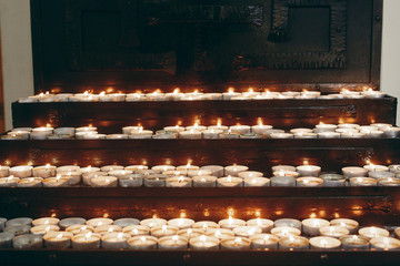 burning candles on altar close-up in  church, lighting candle, mourning victims in terrorism attacks and revolutions, sadness moment. funeral, faith and memory concept