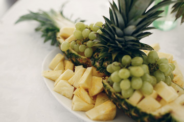 Delicious pineapple fruit in wedding reception table close-up, healthy fruit pineapple and grapes at snack dining table, restaurant catering concept